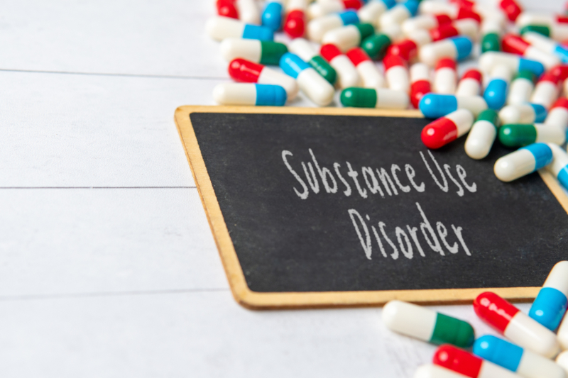 photo of pills with chalkboard stating substance use disorder