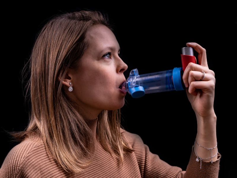 photo of woman using inhaler with spacer