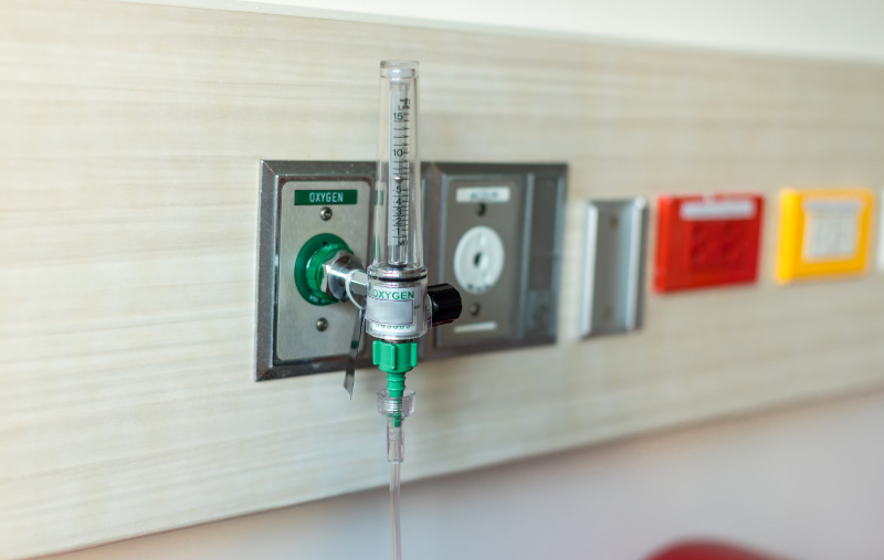 photo of oxygen wall tap with flow meter and tubing in hospital room
