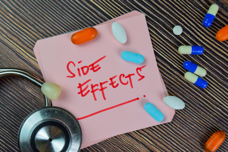 photo of side effects written on note with pills
