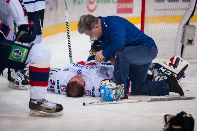 photo of athletic trainer assessing hockey injury