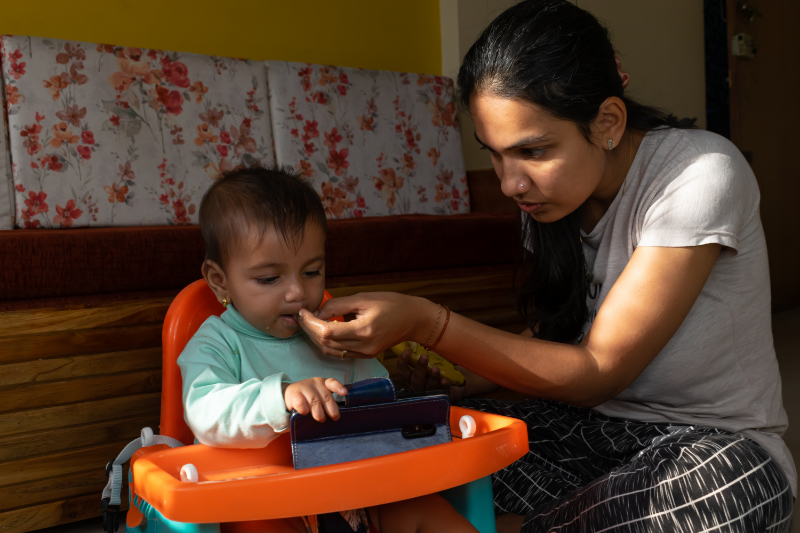 photo of infant on smartphone while being fed